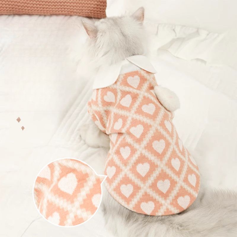 Cat wearing pink and white heart-patterned anti-shedding outfit.