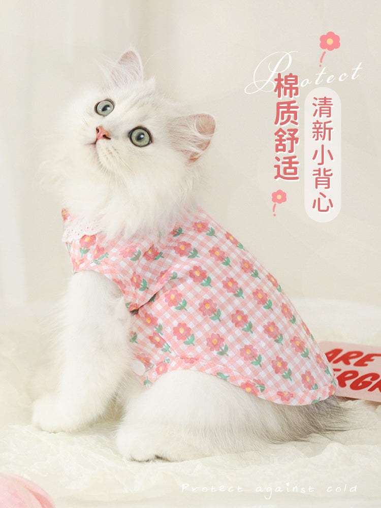 White kitten wearing a pink summer thin anti-shedding vest with floral design.