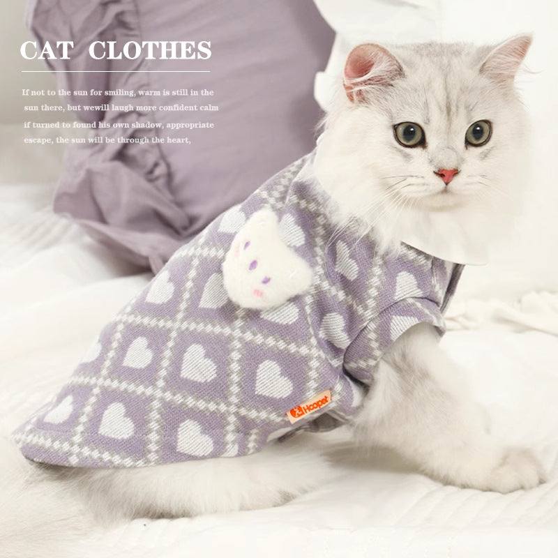 Cat wearing anti-shedding clothes, purple with heart patterns.