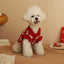 Bichon Frise wearing red New Year cat clothing sweater indoors.