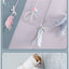 Cat playing with a feathered teaser wand toy against a gray background.