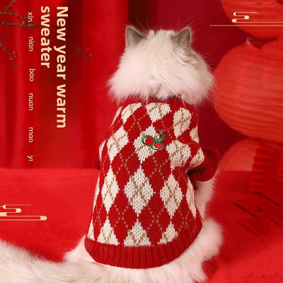 New Year cat wearing red and white sweater with festive decor.