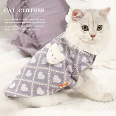 Cat wearing anti-shedding clothes, purple with heart patterns.
